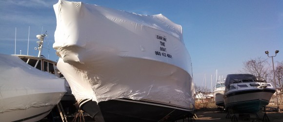 photo of a boat with white shrink wrapping covering it. An example of a service offered.
